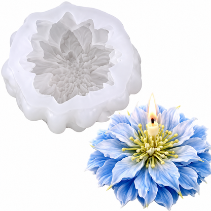 A white flower-shaped silicone mold shown next to a blue and white flower candle with a lit wick, on a plain white background.