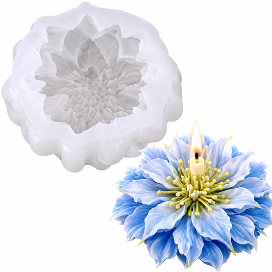 A white flower-shaped silicone mold shown next to a blue and white flower candle with a lit wick, on a plain white background.