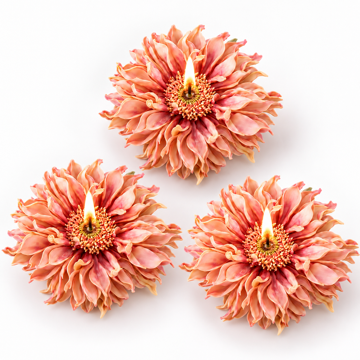 Three peach-pink flower-shaped candles with lit wicks, arranged on a plain white background.