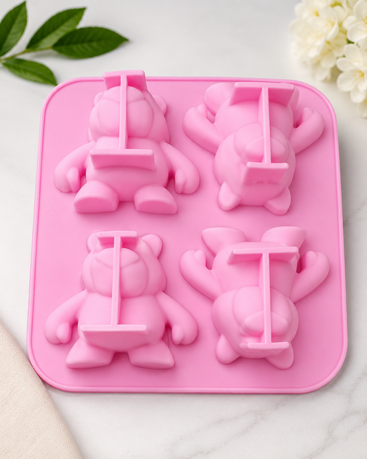 Pink silicone mold with bear and swing design on a white background