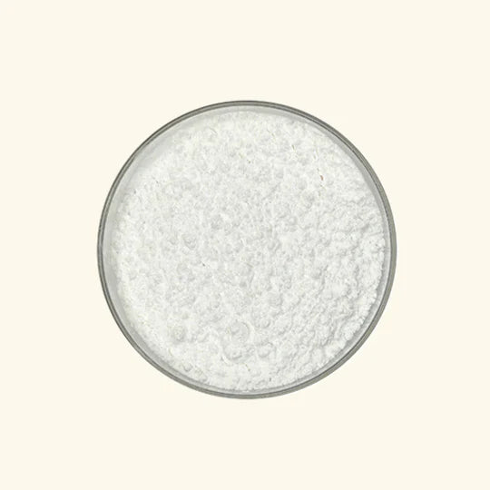 White granular substance in a glass bowl on a light beige background