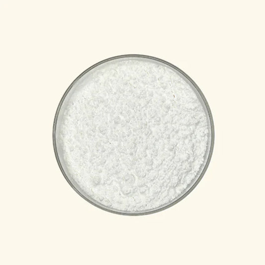 White granular substance in a glass bowl on a light beige background