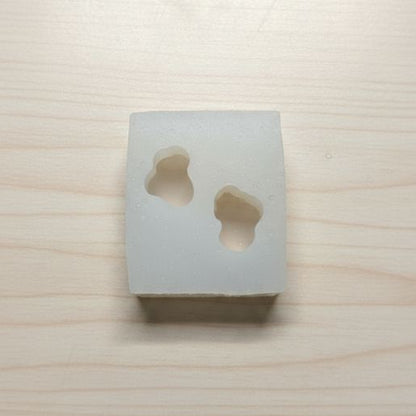 Square concrete block with two circular holes on a wooden surface