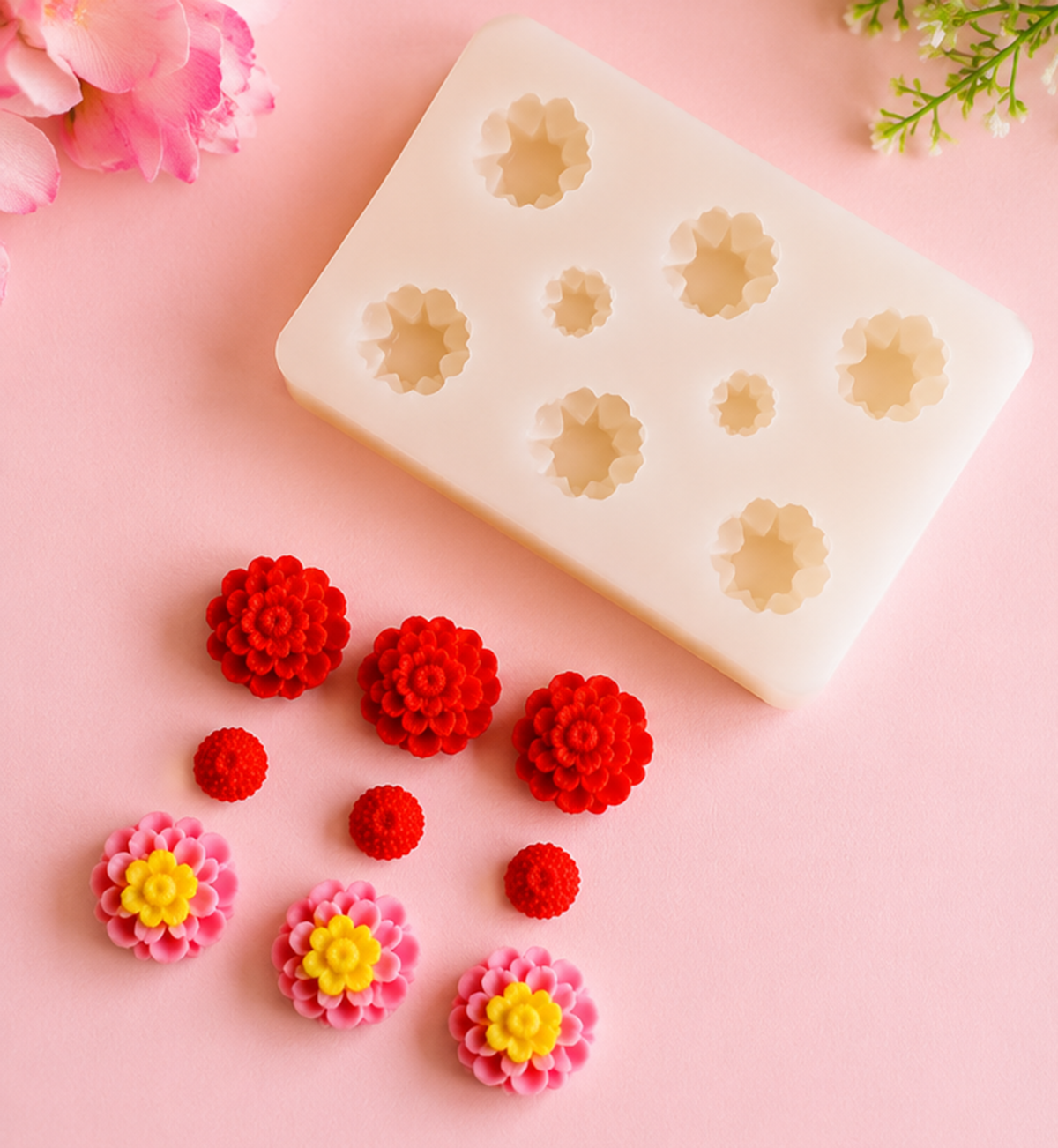 Silicone mold with flower shapes on a pink background with decorative flowers.