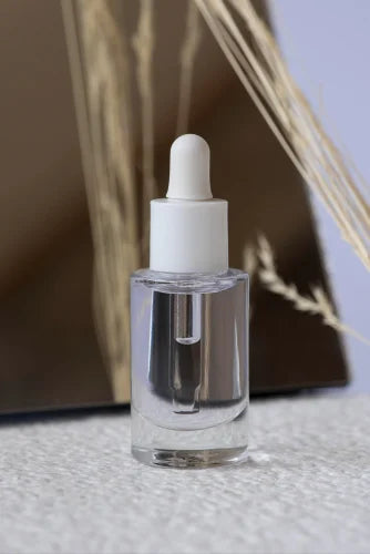 Clear dropper bottle with white cap on a neutral background