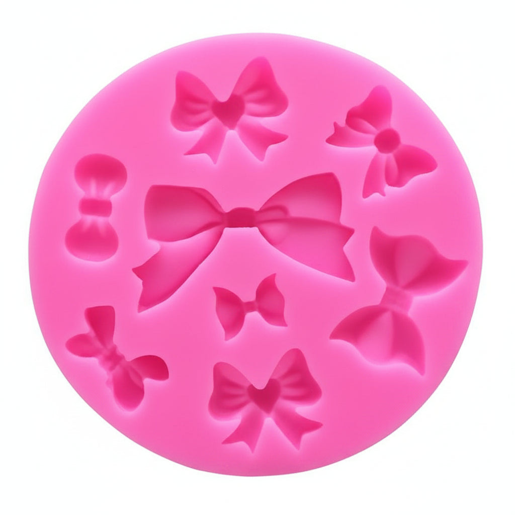 Pink silicone mold with bow shapes on a white background