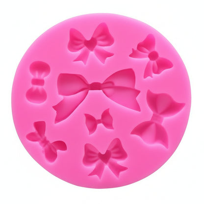 Pink silicone mold with bow shapes on a white background